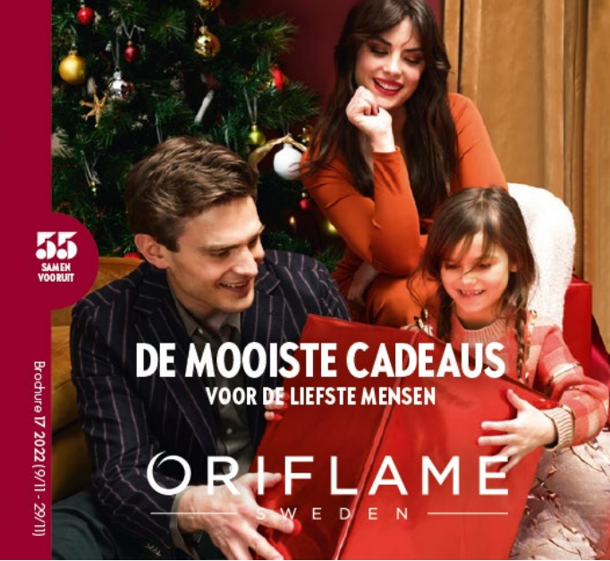 Afbeelding van man, vrouw en meisje bij de kerstboom cadeaus aan het uitpakken van Oriflame van brochure 17